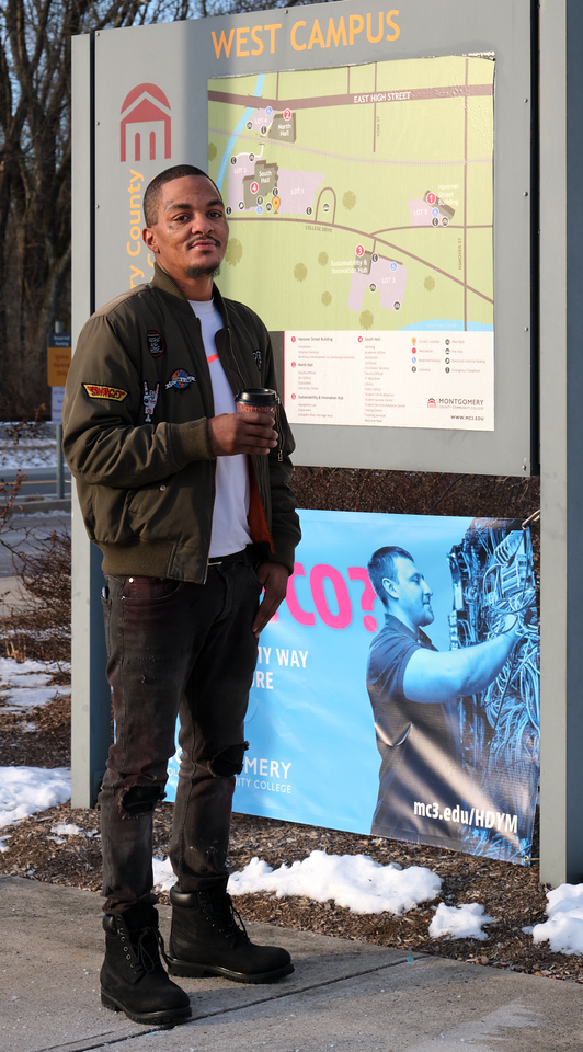 Michael standing in front of a poster at Montgomery County Community College.
